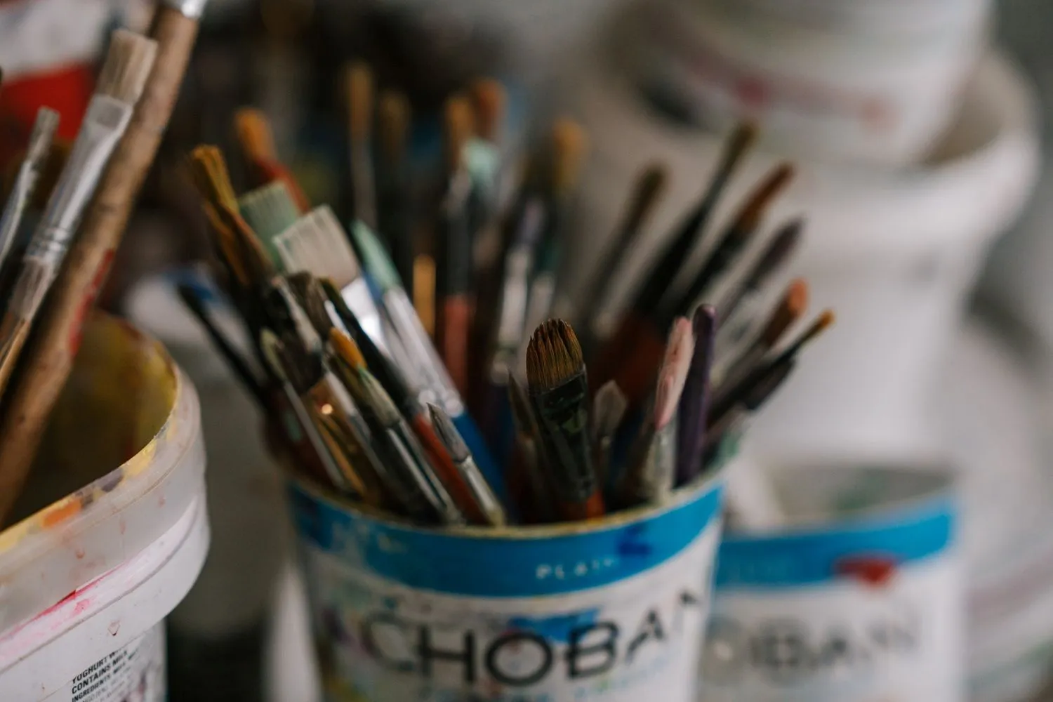 A pile of art brushes in container.